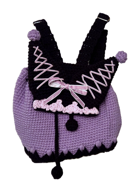 Handmade lavender and black crochet mini backpack, closed front view with pom-pom ears and pink ribbon bow